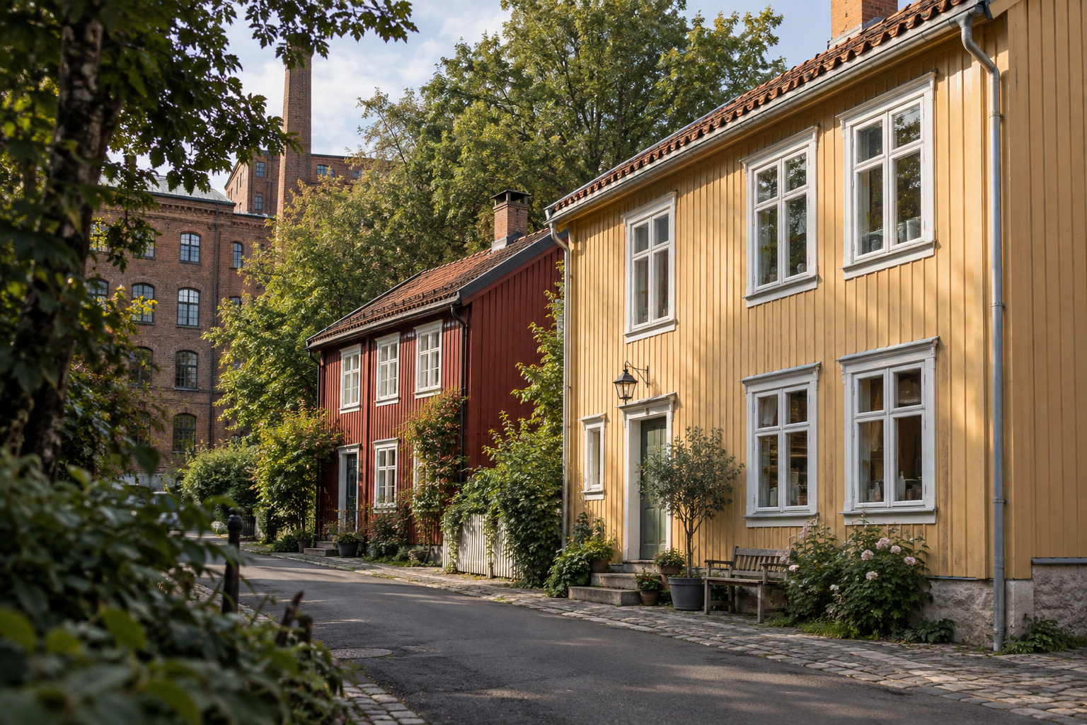 Gule og røde trehus med hvite vindusrammer og et teglbygg i bakgrunnen